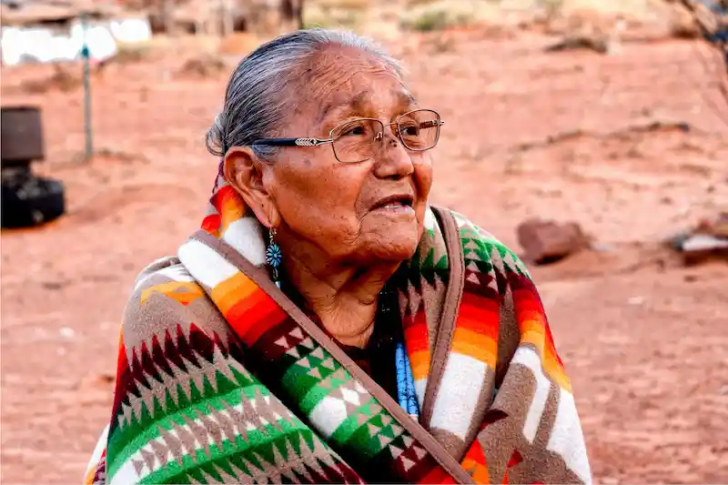 Image of an indigenous older adult in a bright blanket